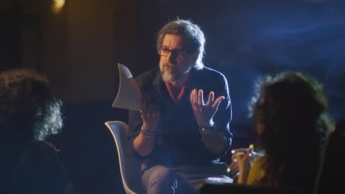 Mature Theater Director Working with Actors on Stage