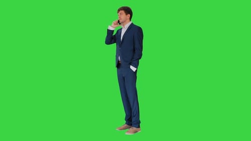 Handsome Young Businessman Talking on the Phone on a Green Screen, Chroma Key.