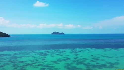 Beautiful seascape with blue turquoise sea full of coral reef patterns, washing cliffs on coastline
