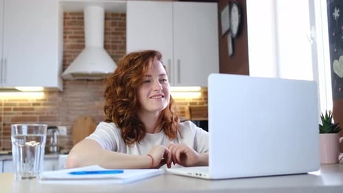Woman Communicating on Laptop in Bright Kitchen