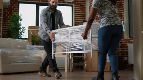 Couple Moving Furniture Into New Apartment