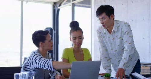 Muti-ethnic business colleagues discussing over laptop in a meeting at modern office 4k