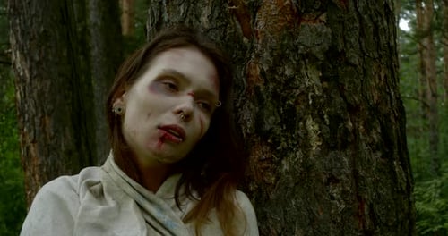 Visage rapproché d'une femme violemment battue debout dans les bois avec un coup sur le visage