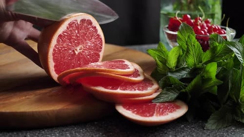 Slicing Grapefruit with Mint and Currants on Board