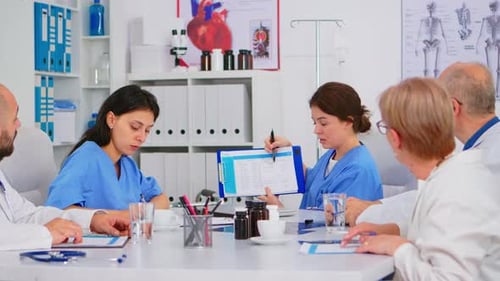 Team of Doctors Sitting in Conference Hospital Office Room Discussing