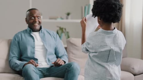 Child Gives Father's Day Card to Adult