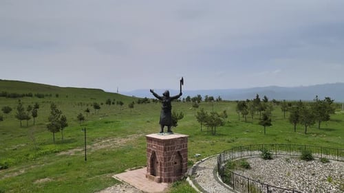 Statue in Green Field From Above on Overcast Day