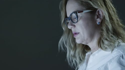 Businesswoman Using Laptop in Dark Office