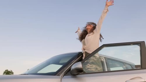 Woman Enjoys Car Ride in the Countryside