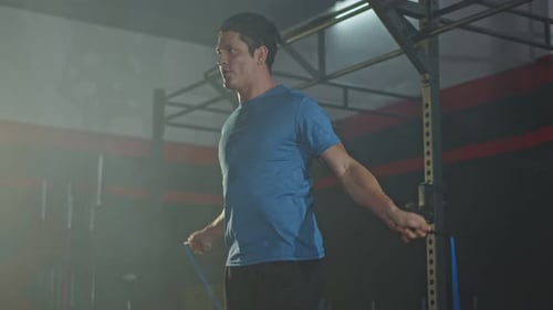 Caucasian young athlete or sport man working out exercise using jumping rope in gym or fitness.