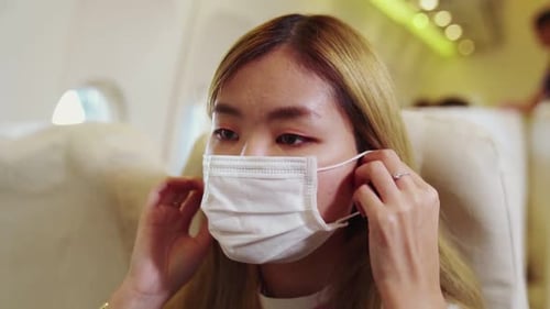 Traveler Wearing Face Mask While Traveling on Commercial Airplane