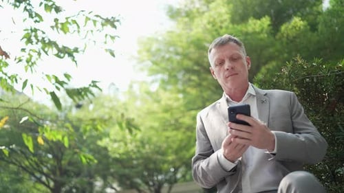 Man in Suit Takes Surprising Phone Call Outdoors