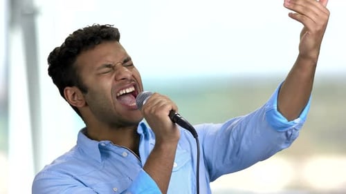 Man Singing Passionately Into Microphone