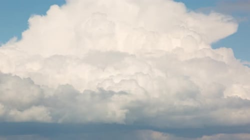 Puffy White Clouds Moving in Blue Sky