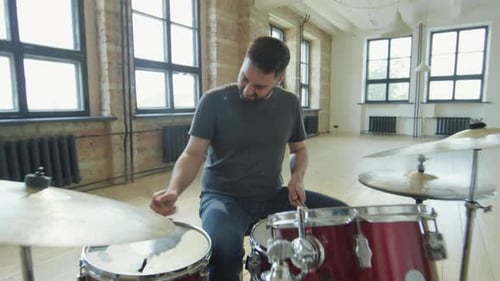 Professional Male Drummer Playing Drumkit