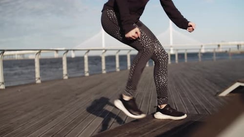 Athletic Woman Exercising on Waterfront Boardwalk
