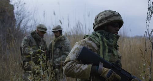 Soldiers Guarding in Overcast Field with Rifles