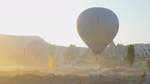 Hot Air Balloons Over Mountainous Landscape at Sunrise