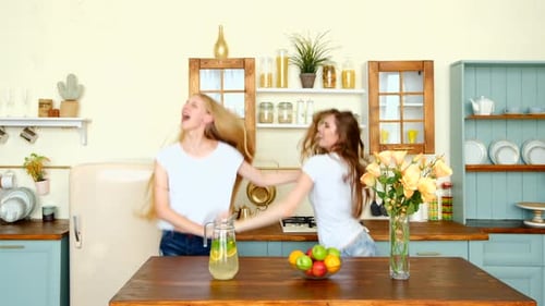 Two Women Dancing Energetically in Bright Kitchen