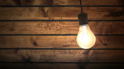 Swinging Incandescent Bulb in Timber-house Darkened Room