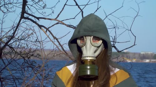 Person with Gas Mask Standing by the Water