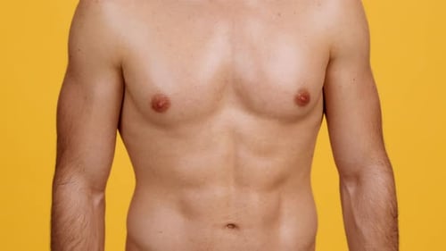 Nahaufnahme eines nicht wiederzuerkennenden muskulösen Mannes ohne Hemd, der seine perfekten Bauchmuskeln demonstriert