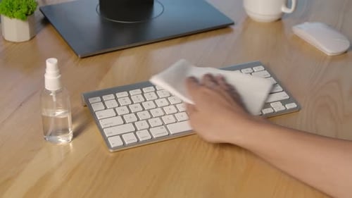 Woman Cleans Keyboard with a Wipe and Sanitizer