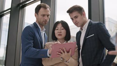 Три бизнесмена используют планшет в офисе