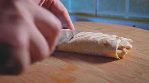 Hands Cutting Anabolic Tuna Wrap. Tuna, Low-fat Cheese, And Broccoli In Tortilla Wrap. close up