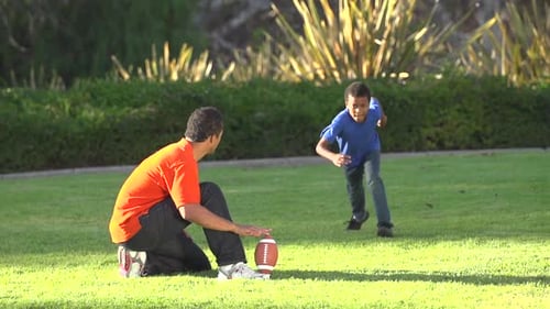 Father and Son Playing Football in the Park