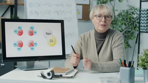 Woman Explains Chemical Diagrams in Classroom Setting