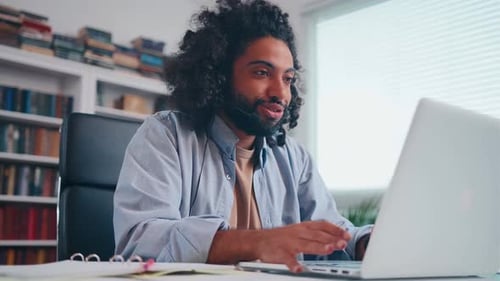 Young Adult Conferencing on Laptop in Home Office