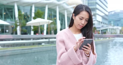 Woman Uses Smartphone in Modern City Setting