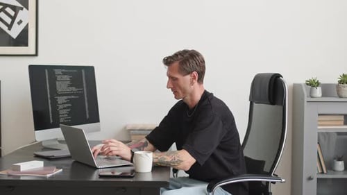 Desarrollador de software escribiendo código de programa en la computadora portátil en la oficina