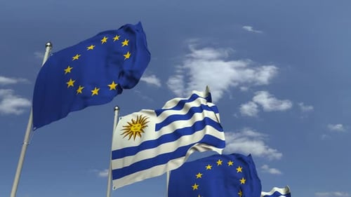 Uruguay and European Union Flags Waving Under Blue Sky