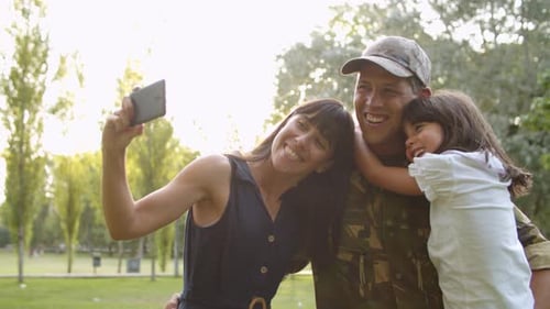 Smiling Family Takes Photo Together in the Park