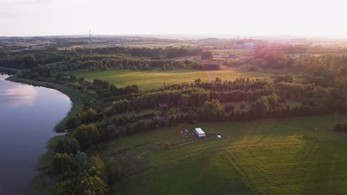 Aerial shot of a secluded lake, surrounded by fields and farms. Relaxing scenery. Beautiful colors.