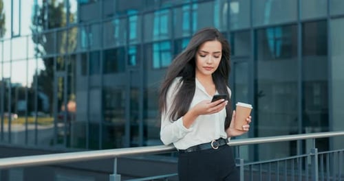 Woman Uses Mobile Phone Outside Modern Office Building
