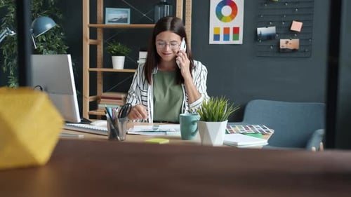 Focused Woman Working at Desk on the Phone