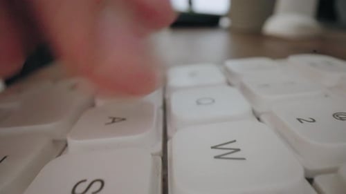 Finger Typing on a White Keyboard Close Up