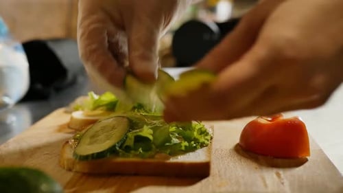 Hands Prepare Fresh Vegetable Sandwich in Kitchen