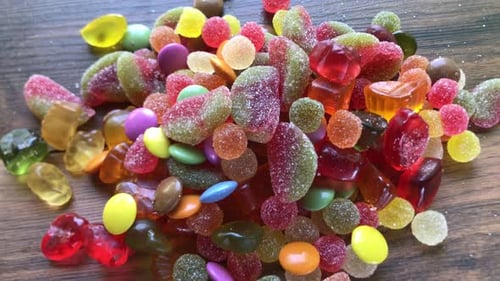 Colorful Pile of Candies on Wooden Surface