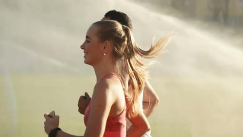 Pareja corre durante el riego de la cancha
