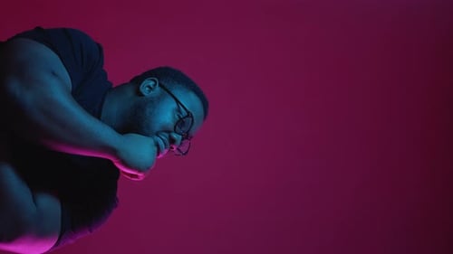 Close-Up of Man Pointing Right in Neon Light