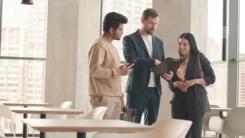 Coworkers Discussing Business Documents in Cafe