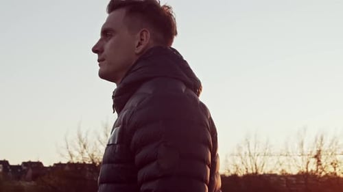 Junger und fitter Mann beim Abendtraining im Freien. Urbaner Sonnenuntergang Hintergrund.