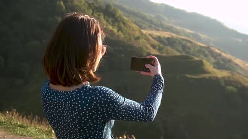 Woman Photographs Mountain View with her Phone