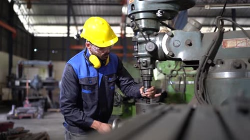 Factory Worker is Setting Up CNC Lathe Machine in Factory , Drill Adjustment