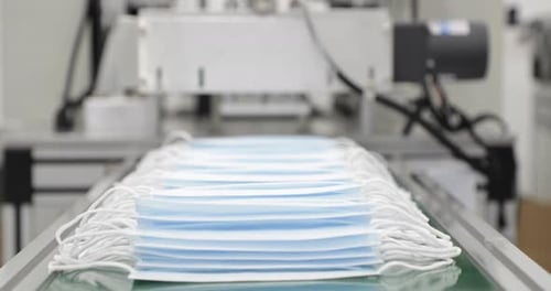 3 Ply Disposable Surgical Mask Coming Out From Machine Into Delivery Mechanism Conveyor. - close up