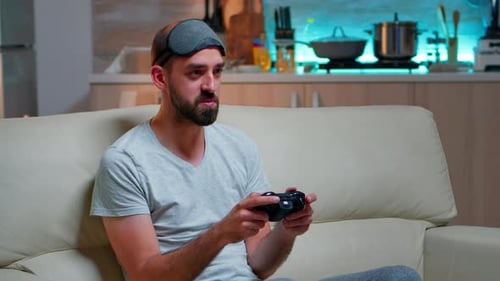Man Plays Video Game Wearing Sleep Mask